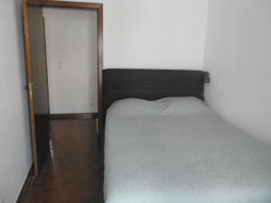 a small bedroom with a bed and an open door at Casa Barrela II in Tavira