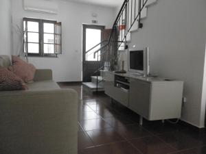 a living room with a couch and a tv at Casa Barrela II in Tavira