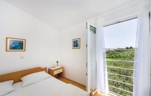 a bedroom with a bed and a large window at Dadić Apartments in Bibinje