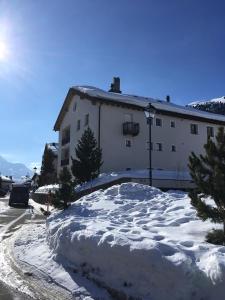 una gran pila de nieve frente a un edificio en Palüdetta 8, en Silvaplana