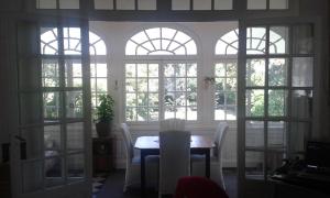 a dining room with windows and a table and chairs at Vanille Bourbon in Montauban