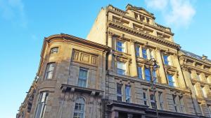 a large stone building with a blue sky in the background at Grey Street Hotel in Newcastle upon Tyne