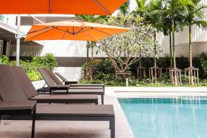 a group of chairs and umbrellas next to a pool at Phuket Town 1 Bedroom Condo Luxury Facilities, The Base Downtown in Phuket Town