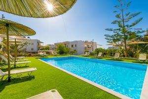 una piscina con sillas y un patio con sombrilla en Triton Authentic Cretan Hotel, en Tsoutsouros