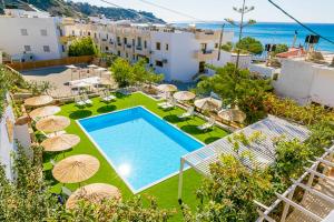 an overhead view of a swimming pool with umbrellas at Triton Authentic Cretan Hotel in Tsoútsouros
