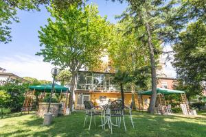 een tuin met stoelen en tafels voor een gebouw bij Hotel del Falco in Cervia