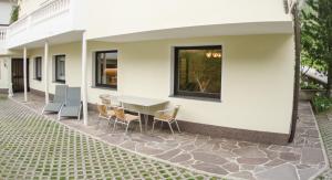 eine Terrasse mit einem Tisch und Stühlen neben einem Gebäude in der Unterkunft ISIS---Ferienwohnung in Steinach am Brenner