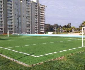 un campo de fútbol vacío frente a un edificio en Departamento algarrobo laguna vista, en Algarrobo