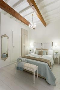 a white bedroom with a large bed and a chandelier at Accademia Gallery Charming Suite in Florence