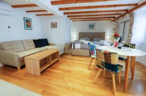 sala de estar con sofá, mesa y cama en Castellum Apartments, en Dubrovnik
