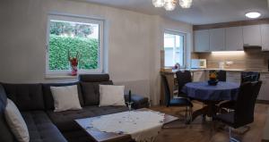 ein Wohnzimmer mit einem Sofa und einem Tisch sowie eine Küche in der Unterkunft ISIS---Ferienwohnung in Steinach am Brenner