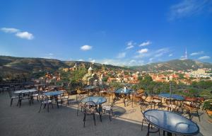 un grupo de mesas y sillas con vistas a la ciudad en Hotel Kopala, en Tiflis