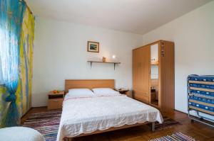 Schlafzimmer mit einem Bett und einem Holzschrank in der Unterkunft Apartments Cvita Ugljan in Ugljan