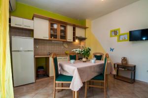eine Küche mit einem Tisch und Stühlen im Zimmer in der Unterkunft Apartments Cvita Ugljan in Ugljan