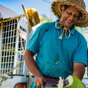 a man in a hat is cutting a banana at Butterfly Hostel in Saint-François +7 photos