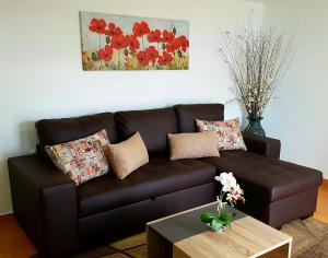 a brown couch in a living room with a coffee table at La Casa de la Abuela in Ponta do Sol