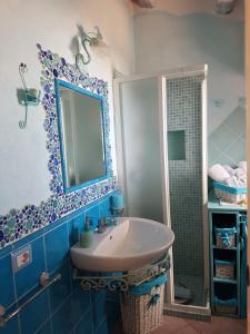 y baño con lavabo, espejo y ducha. en Villetta Tavolara, en Porto San Paolo