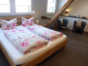 een bed met roze en witte lakens en kussens bij Der Weinladen in Kröv