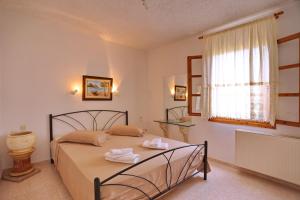 a bedroom with a bed with two towels on it at Marlitsis Apartments & Studios in Skopelos Town