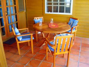 a wooden table and chairs on a patio at Seascape Beach House Surferspoint Barbados in Christ Church