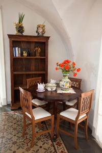 カターニアにあるIl Cortilettoのダイニングルームテーブル(椅子付)、花瓶