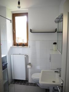 a white bathroom with a toilet and a sink at "Glücksmoment" in Bad Kreuznach