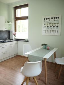 a white kitchen with a table and chairs at "Glücksmoment" in Bad Kreuznach