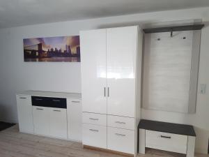 a kitchen with white cabinets and a painting on the wall at Hotel Ari in Kaiserslautern