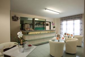 a restaurant with a counter with white chairs and a table at Residence "Canta" in Pescara