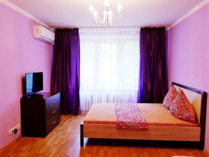 モスクワにあるКвартира посуточно метро Пролетарскаяの紫の壁のベッドルーム1室、ベッド1台、窓が備わります。