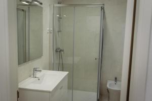 a bathroom with a glass shower and a sink at Casinhas Da Vila in Monção