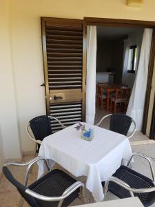 une table blanche avec des chaises et une boîte sur celle-ci dans l'établissement Viviendas Es Carritx, à La Mola