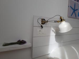 - une lampe assise sur un lavabo dans la salle de bains dans l'établissement Viviendas Es Carritx, à La Mola
