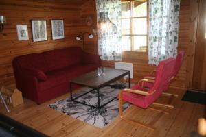 a living room with a red couch and a table at Ekströms Stugor in Gottby