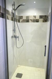 La salle de bains est pourvue d'une douche avec une porte en verre. dans l'établissement Envies en Lubéron, à Saignon