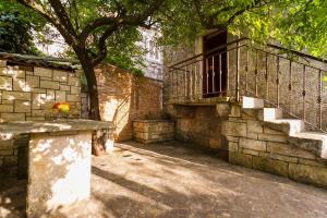 a stone building with a staircase and a tree at Old Small Stone House in Korčula