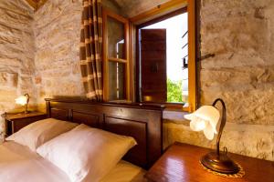 a bedroom with a bed and a table with a lamp at Old Small Stone House in Korčula