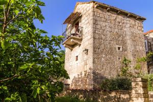 a man sitting on a balcony of a castle at Old Small Stone House in Korčula