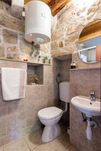 a bathroom with a toilet and a sink at Old Small Stone House in Korčula