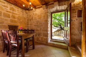 a dining room with a table and a window at Old Small Stone House in Korčula