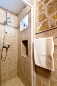 a bathroom with a shower with a glass door at Old Small Stone House in Korčula