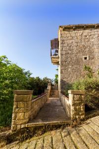 a stone staircase leading up to a building with a balcony at Old Small Stone House in Korčula