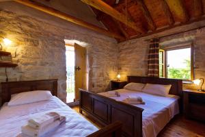 a bedroom with two beds and two windows at Old Small Stone House in Korčula