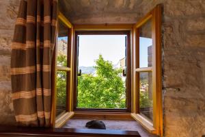 a cat sitting in front of a window at Old Small Stone House in Korčula
