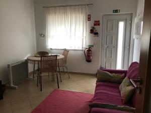 a living room with a couch and a table at Apartamento Porto de Areia in Peniche