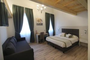 um quarto com uma cama e um sofá em Elisa Guest House em Florença