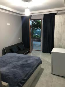 a bedroom with a bed and a sliding glass door at 15 Kviparosi Guest House in Makhinjauri