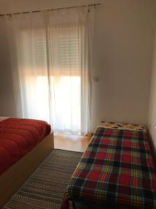 a bedroom with a bed and a window at Apartamento Porto de Areia in Peniche