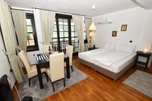1 dormitorio con cama, mesa y comedor en Villa Lollobrigida, en Ohrid