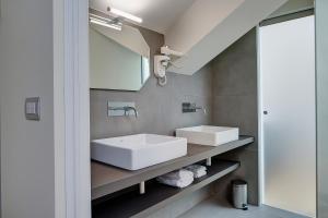 La salle de bains est pourvue d'un lavabo blanc et d'un miroir. dans l'établissement T7, à Milan